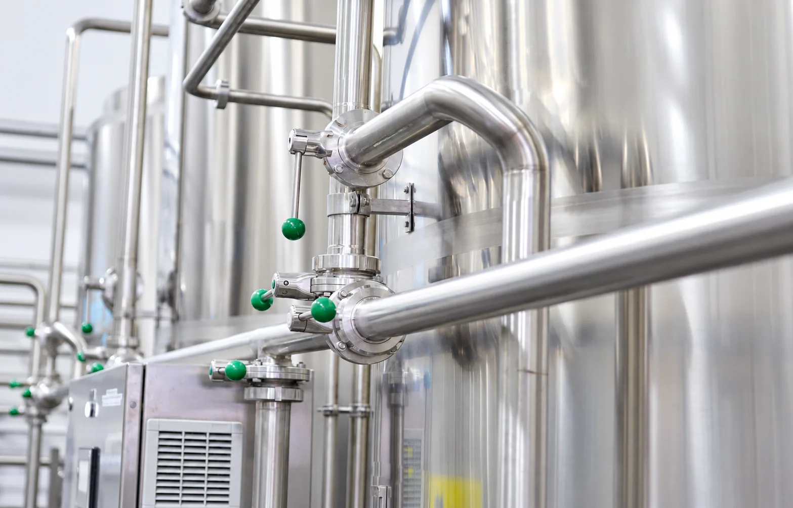 Polished stainless-steel tanks, pipes and valves in a liquid-food processing facility